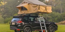 A tent mounted to the roof of a Toyota Forester
