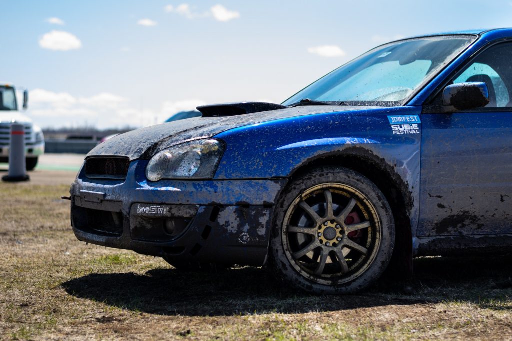Blue Toyota STI covered in brown mud